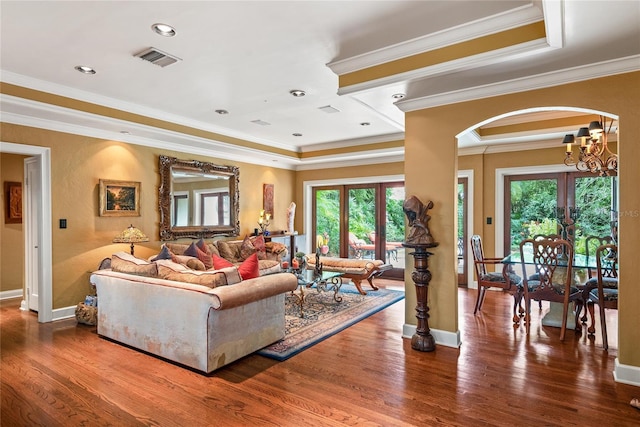 living room with french doors, hardwood / wood-style flooring, an inviting chandelier, and ornamental molding