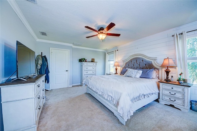 bedroom featuring ceiling fan, light colored carpet, a textured ceiling, and crown molding