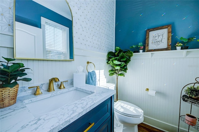 bathroom featuring vanity, toilet, ornamental molding, and wood-type flooring