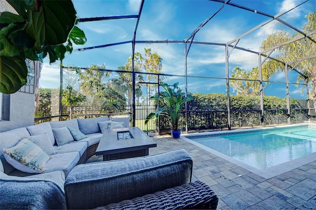 view of pool with a lanai, a patio area, and an outdoor living space with a fire pit