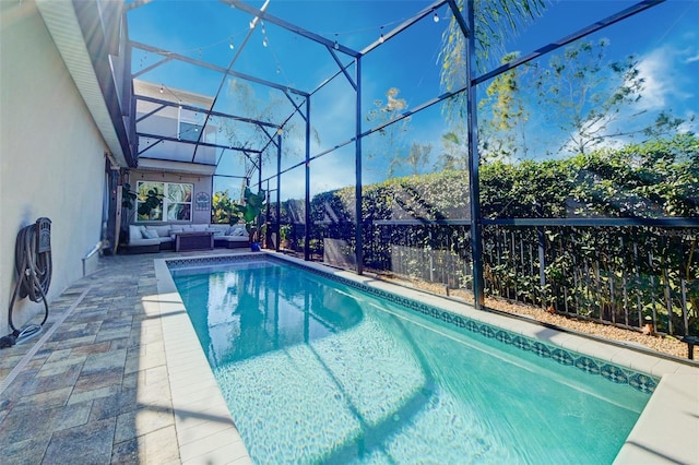 view of pool featuring outdoor lounge area, a patio, and a lanai