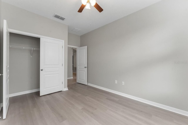 unfurnished bedroom with ceiling fan, a closet, and light hardwood / wood-style floors