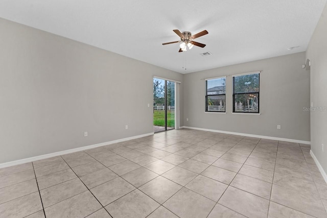 tiled empty room featuring ceiling fan