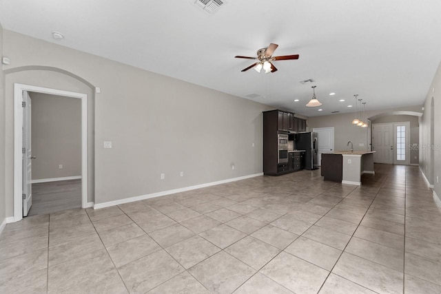 unfurnished living room featuring ceiling fan and light tile patterned flooring