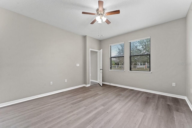 unfurnished room with ceiling fan, light hardwood / wood-style floors, and a textured ceiling