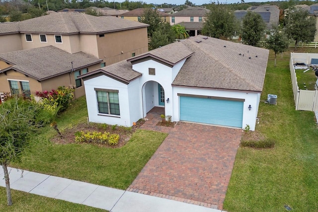 view of front of property featuring central air condition unit, a front yard, and a garage