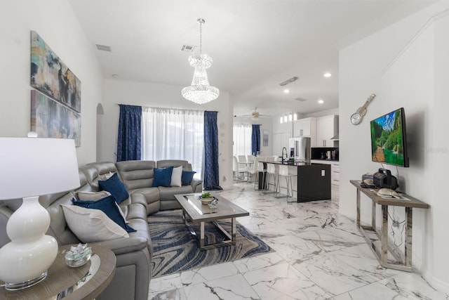 living room with ceiling fan with notable chandelier