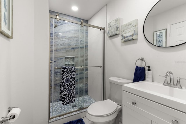 bathroom with vanity, an enclosed shower, and toilet