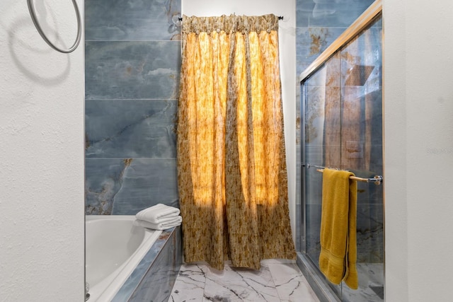 bathroom featuring independent shower and bath and tile walls