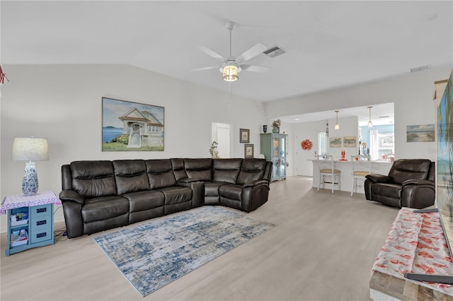 living room featuring ceiling fan, light hardwood / wood-style flooring, and lofted ceiling