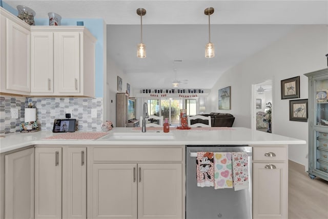 kitchen with dishwasher, lofted ceiling, backsplash, sink, and hanging light fixtures