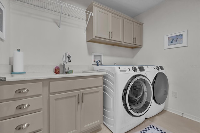 laundry area with washer and dryer, cabinets, and sink