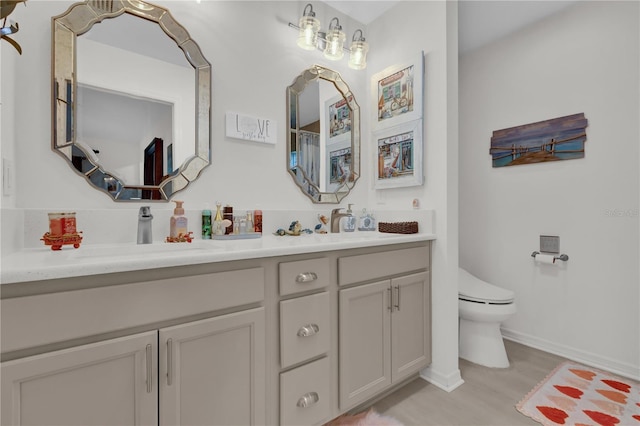 bathroom with wood-type flooring, vanity, and toilet