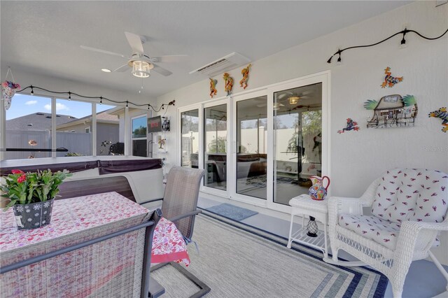 view of patio with ceiling fan and a hot tub