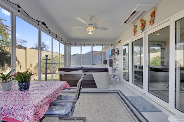 sunroom / solarium featuring ceiling fan and a hot tub