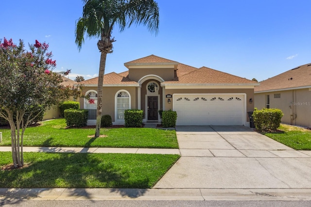 mediterranean / spanish-style house featuring a front yard and a garage