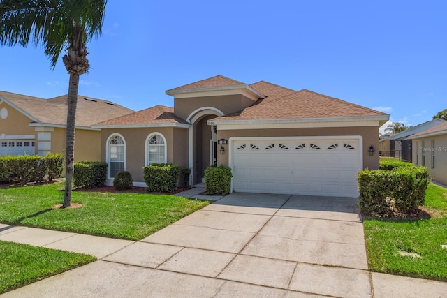 mediterranean / spanish house with a front yard and a garage