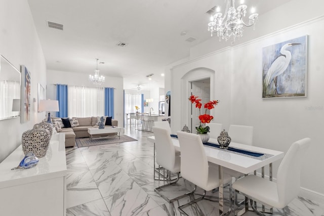 dining space with sink and an inviting chandelier