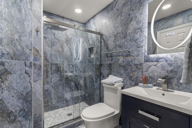 bathroom featuring vanity, an enclosed shower, tile walls, and toilet