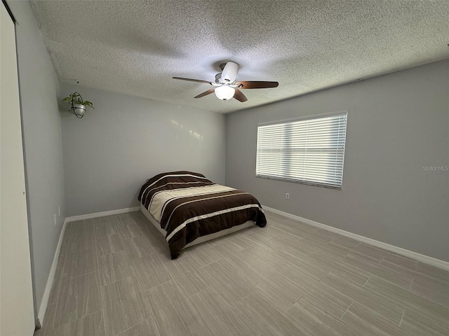 bedroom with ceiling fan and a textured ceiling