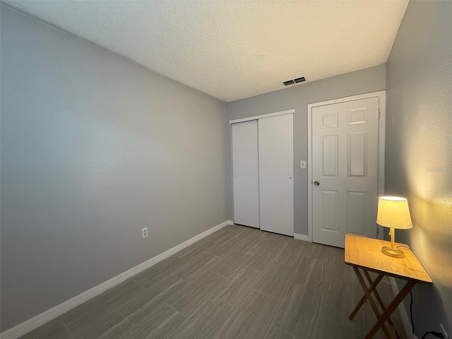 unfurnished bedroom with a textured ceiling and a closet