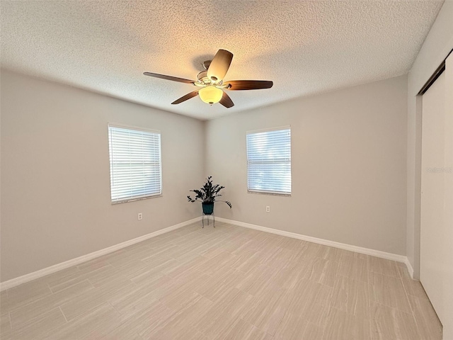 spare room with ceiling fan, plenty of natural light, and a textured ceiling