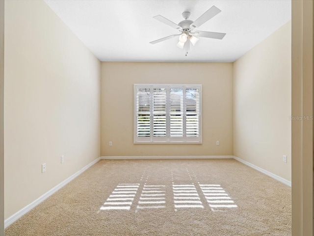 spare room with ceiling fan and light colored carpet