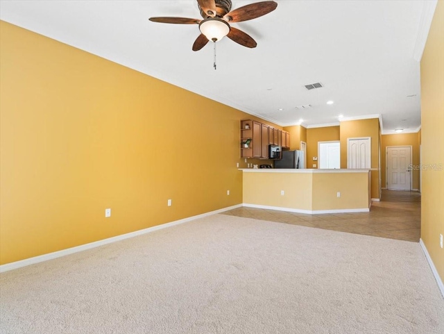 unfurnished living room featuring ceiling fan, ornamental molding, and light carpet