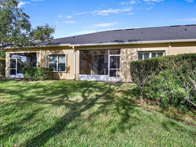 rear view of property featuring a lawn