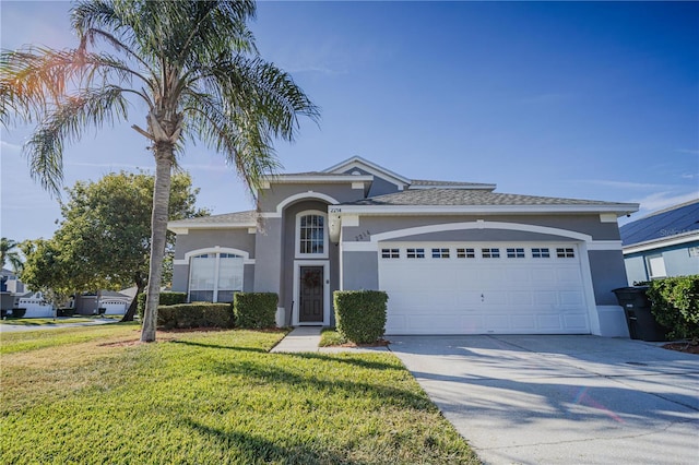 view of front of property featuring a garage and a front lawn