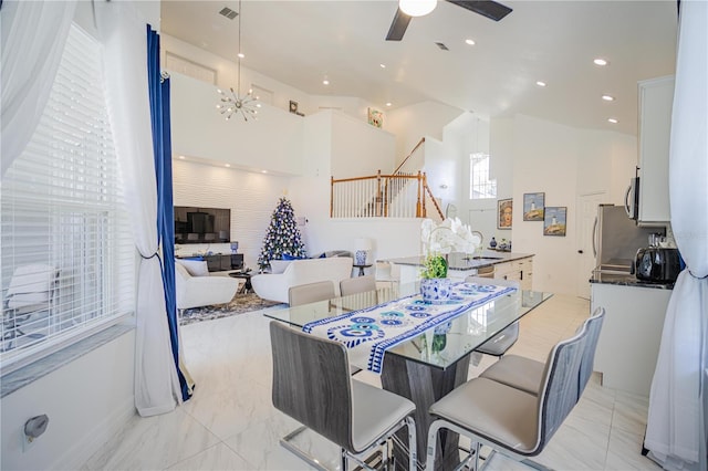 dining area featuring ceiling fan with notable chandelier