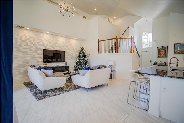 living room with a chandelier, a high ceiling, and sink