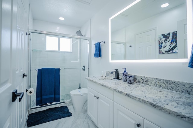 bathroom featuring a shower with door, vanity, and toilet