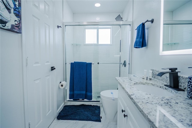 bathroom featuring vanity, a shower with shower door, and toilet