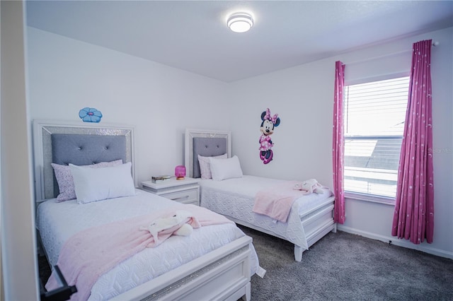 bedroom featuring dark colored carpet and multiple windows