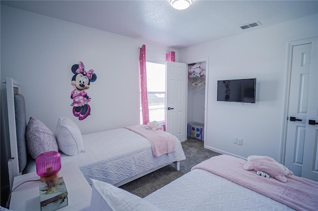 bedroom with dark colored carpet and a textured ceiling