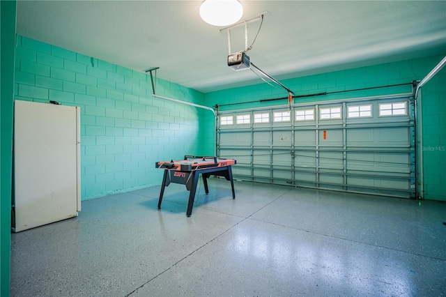 garage with white fridge and a garage door opener