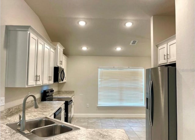 kitchen with white cabinets, light tile patterned flooring, sink, and stainless steel appliances