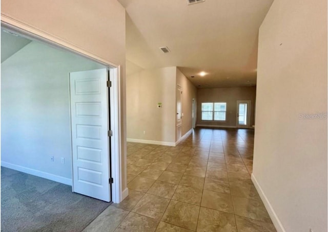 hall with tile patterned floors