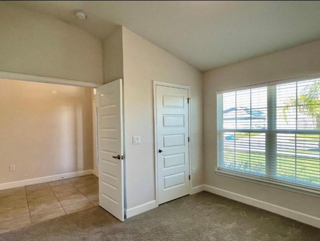 unfurnished bedroom with carpet floors and vaulted ceiling