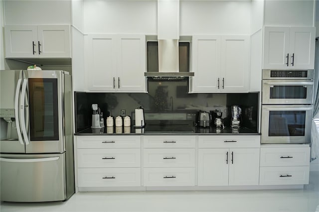 kitchen featuring decorative backsplash, stainless steel appliances, white cabinetry, and wall chimney exhaust hood