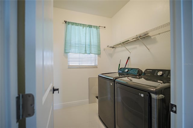 laundry area featuring light tile patterned floors and washer and dryer