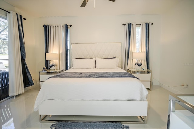 tiled bedroom featuring ceiling fan and multiple windows