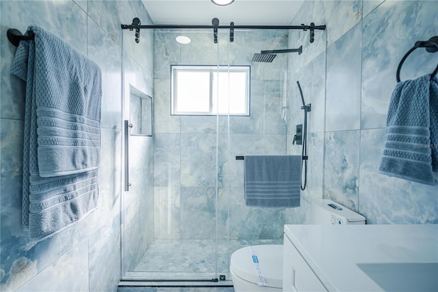 bathroom with vanity, toilet, a shower with shower door, and tile walls