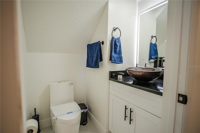 bathroom with vanity, toilet, and lofted ceiling