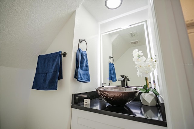 bathroom with vanity and lofted ceiling