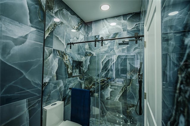 bathroom with a tile shower, tile walls, and toilet