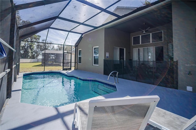 view of swimming pool with ceiling fan, a lanai, and a patio