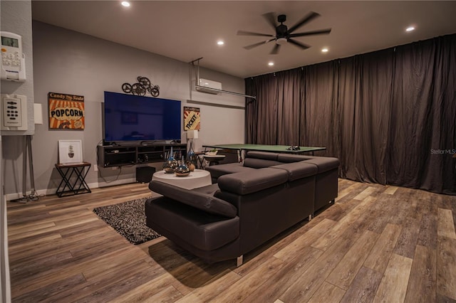 cinema room with light wood-type flooring and ceiling fan