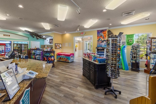 interior space with hardwood / wood-style floors, ornamental molding, and a textured ceiling